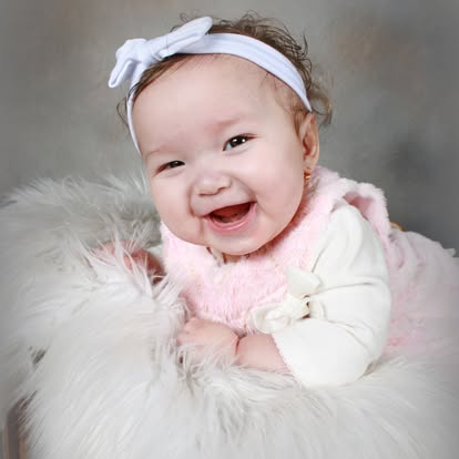 Smiling baby in tulle skirt in woven basket