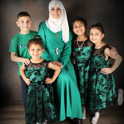 Family of four in green outfits posing together